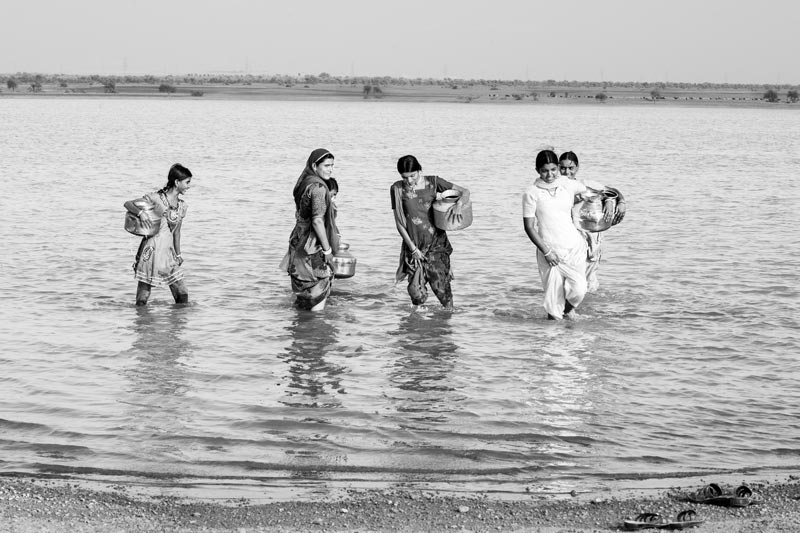 Nature-based solution for quenching thirst in the driest place of India - Village women preparing to leave after  filling their pots with water at Viprasar, a rainfed pond in Thar Desert, Jaisalmer district, Rajasthan